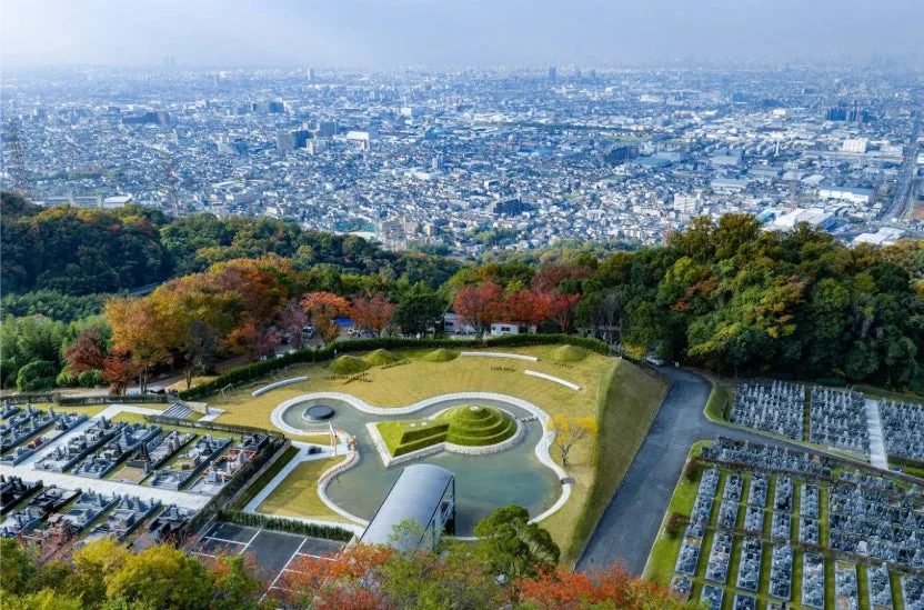 秋の紅葉に彩られた山腹にある広大な霊園の俯瞰写真