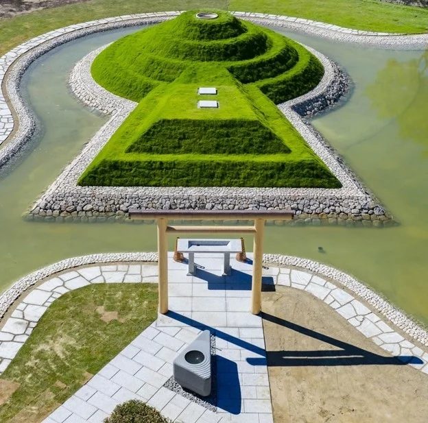 緑豊かな芝生の丘が水辺に囲まれた美しい庭園の空撮