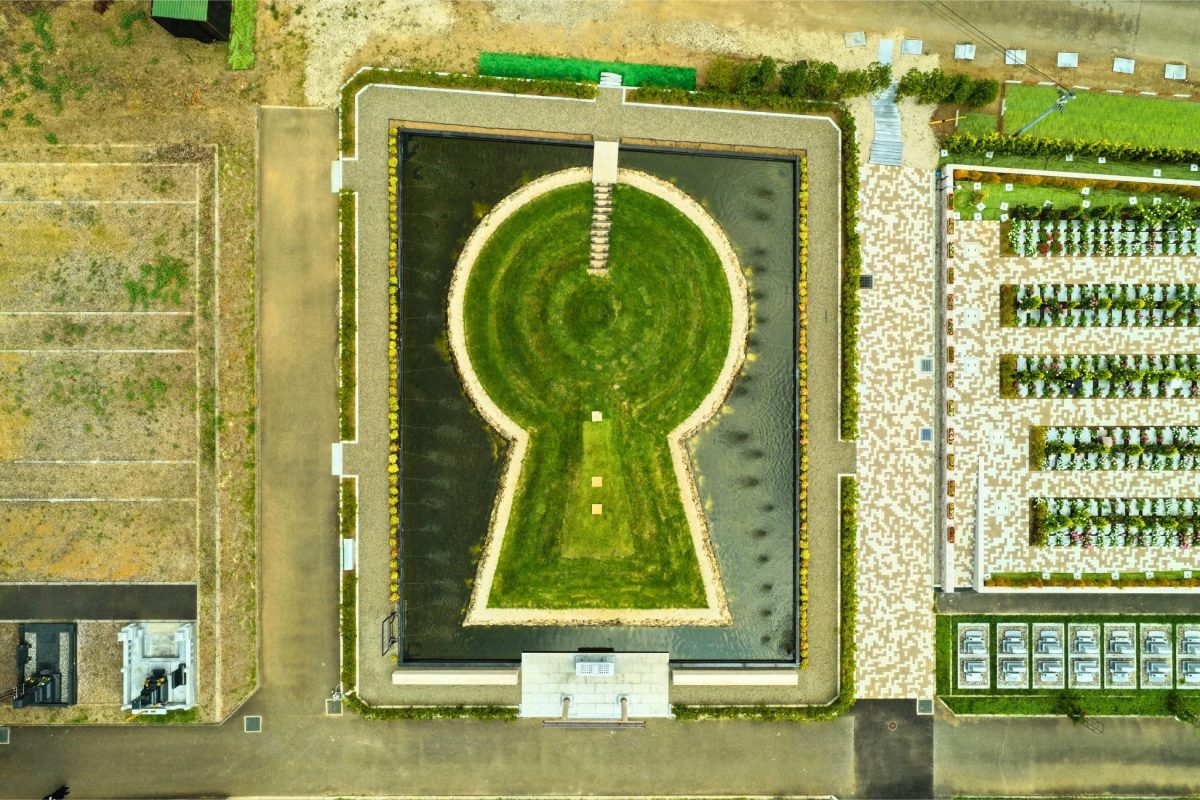 鍵穴の形をした池と緑の島がある霊園の空撮